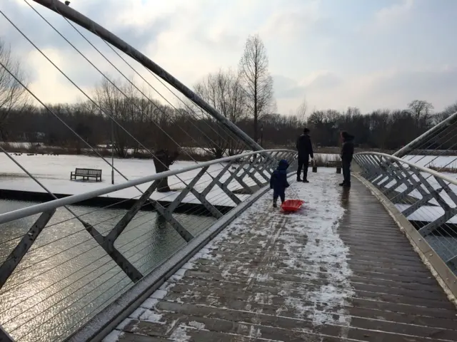 Child with sledge crossing a river