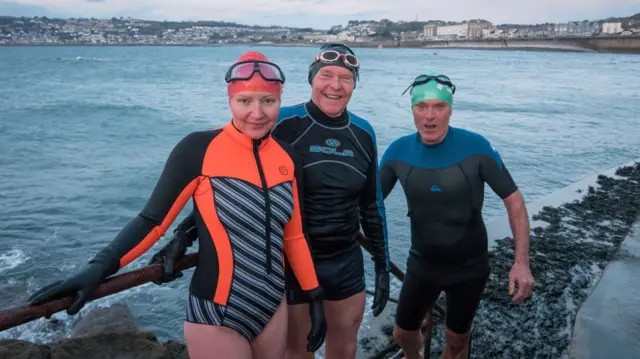 Sea swimmers pose for a photograph after they have taken a early morning swim