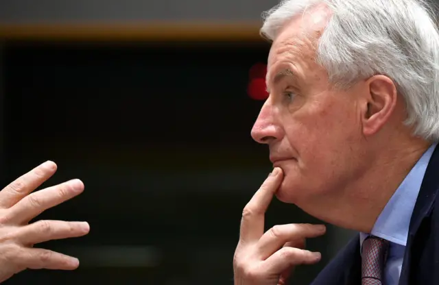 Michel Barnier resting a finger on his chain