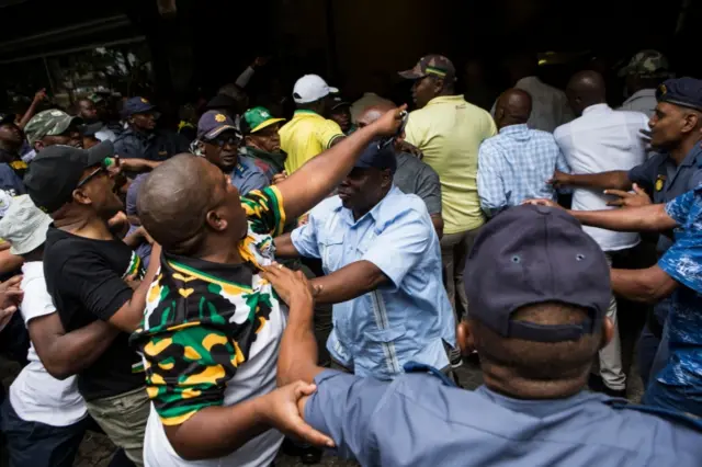 Police hold back African National Congress supporters at the ANC headquarters in Johannesburg