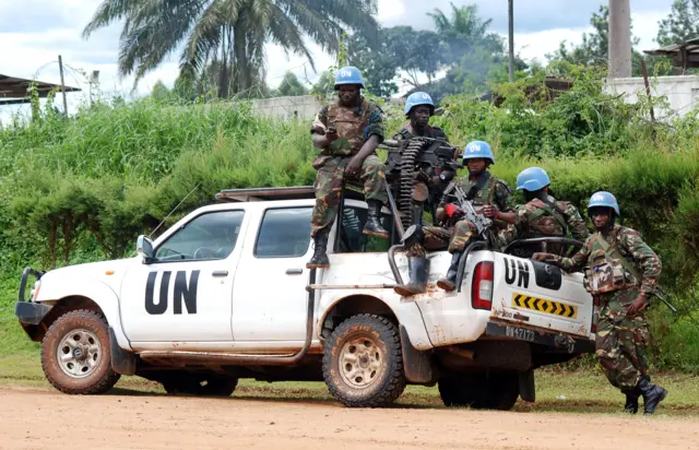 Blue helmet members of the United Nations Organization Stabilization Mission in the Democratic Republic of Congo MONUSCO sit on the back of a UN pick-up truck on October 23, 2014 in Beni