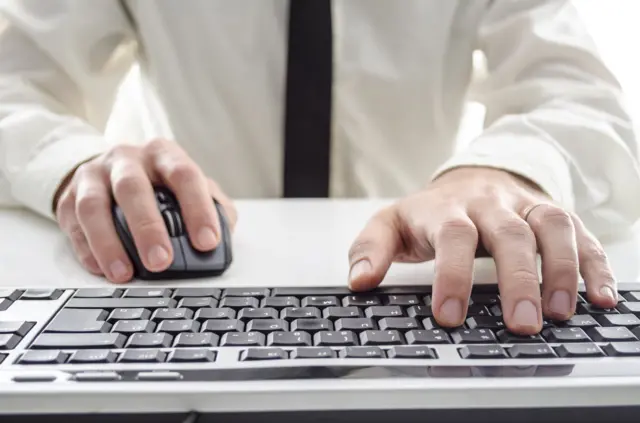 A man working on a computer keyboard