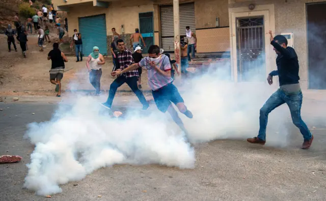 Teargas from security forces enshrouds protesters from the Rif movement during clashes after a demonstration against the government in al-Hoceima on June 8, 2017.