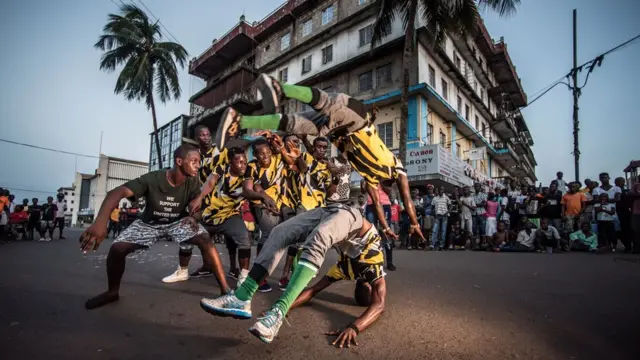 Street dancers perform in front of a crowd in Sierra Leone