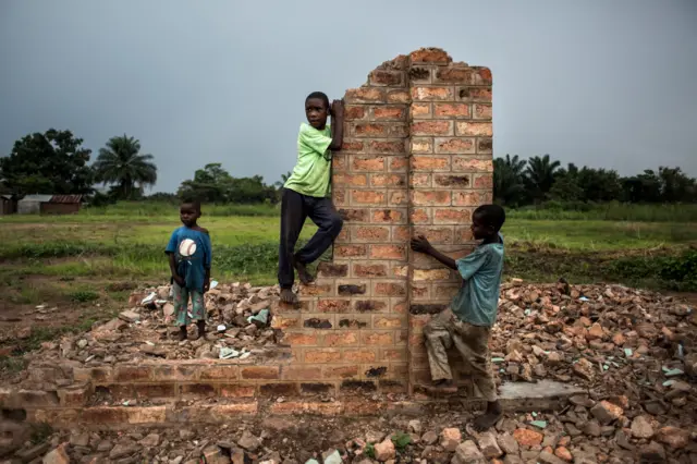 Young Congolese boys play around broken building on October 26, 2017 in Kasala, in the restive region of Kasai, central Democratic Republic of Congo