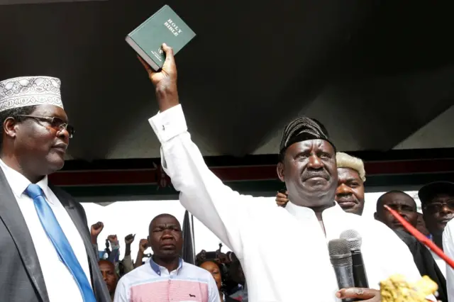 Kenyan opposition leader Raila Odinga of the National Super Alliance (NASA) holds a bible as he takes a symbolic presidential oath of office in Nairobi, Kenya January 30, 2018.