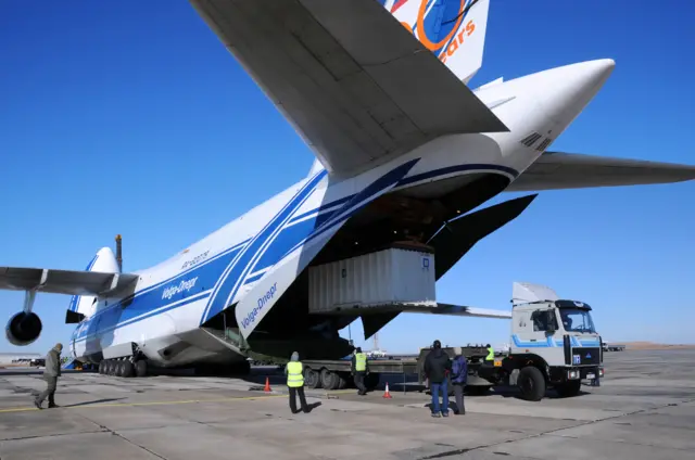 People loading freight on to a plane