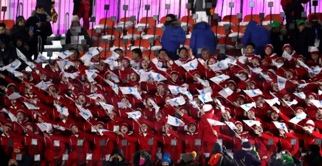 Spectators wave Unified Korea flags