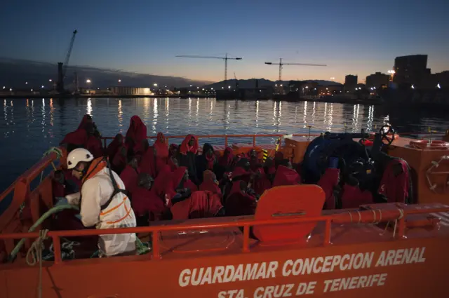 A group of migrants arrive on board a Spanish coast guard vessel, the second one of the day, at the southern Spanish port of Malaga on January 13, 2018 following the rescue of an inflatable boat carrying 55 African people, nine of them women and one child off the Spanish coast.