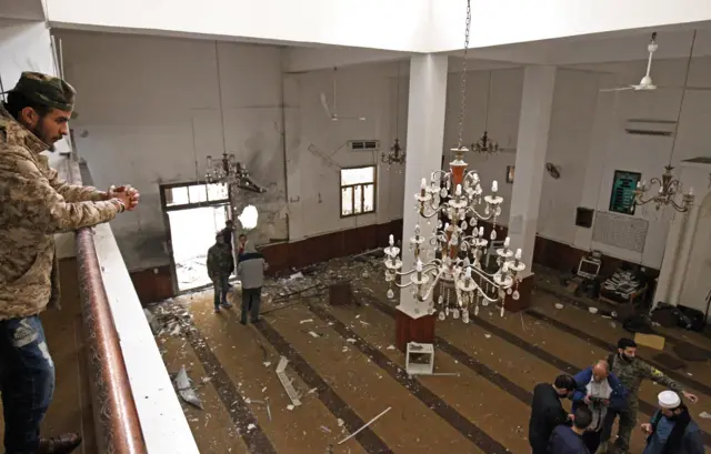 Libyans inspect the interior of a mosque in Benghazi on February 9, 2018, after it was hit with a twin bomb attack