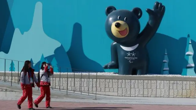 Volunteers walk past a sculpture of a Winter Olympic mascot at the Gangneung Olympic Park in Gangneung, South Korea, 04 February 2018.