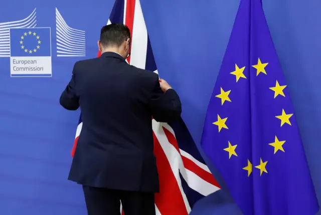 A man arranging an union jack and an EU flag