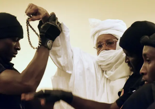 Former Chadian dictator Hissene Habre (C) is escorted by prison guards into the courtroom for the first proceedings of his trial by the Extraordinary African Chambers in Dakar on July 20, 2015.