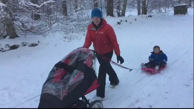 mum taking her 2 kids for a walk in the snow Grantown, pushing a buggy and pulling a sledge