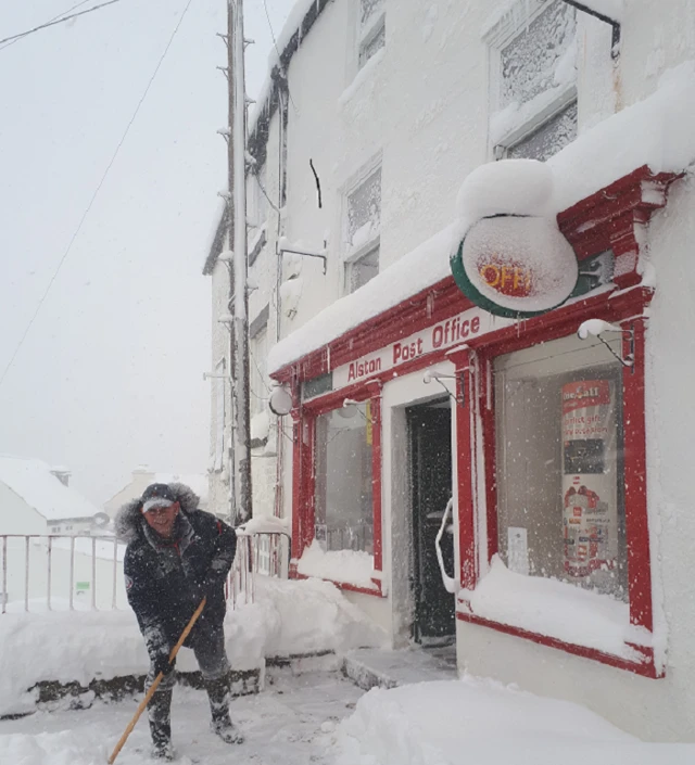 Bryan Cooper, postmaster, clearing snow