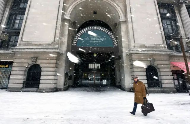 A commuter walks past the Exchange building in Nottingham