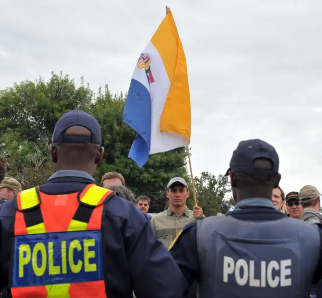 South Africans supporting the white supremacist Afrikaner Resistance Movement (AWB) fly the apartheid era flag on April 6, 2010