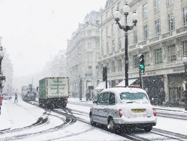 Traffic in central London as snow falls