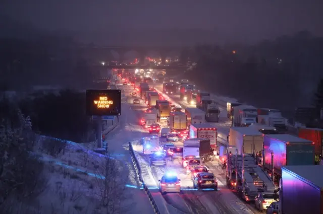 Emergency vehicles manoeuvre past stationary traffic on the M80 Haggs in Glasgow,