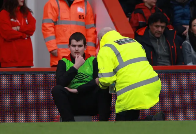 A steward speaks to a ball boy