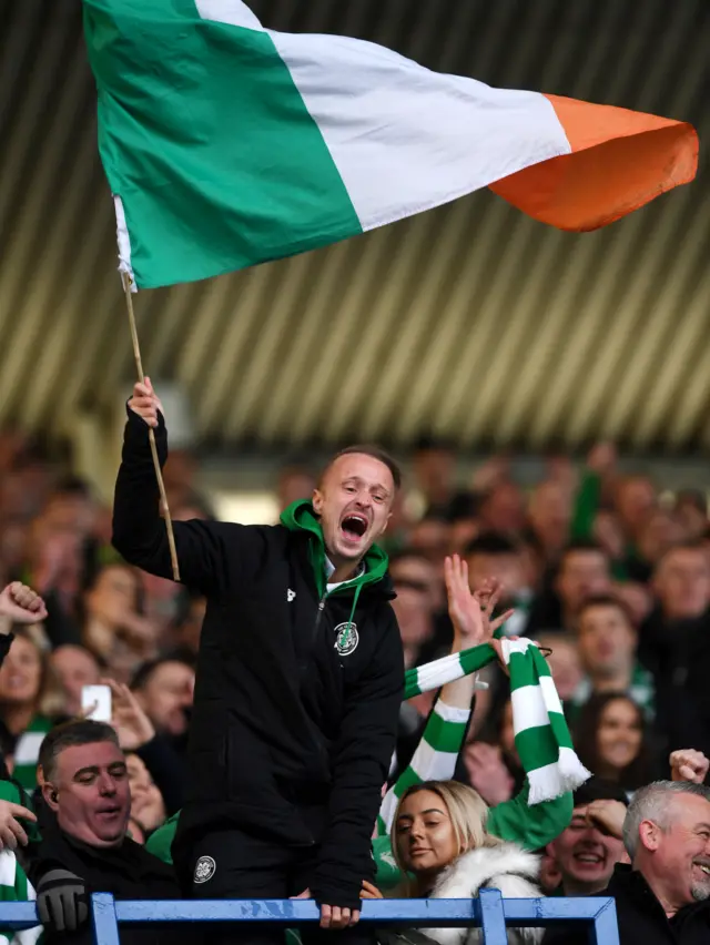 Injured Celtic striker Leigh Griffiths waves a flag in celebration