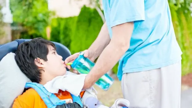 Disabled child using straw