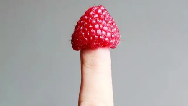 Raspberry on a finger