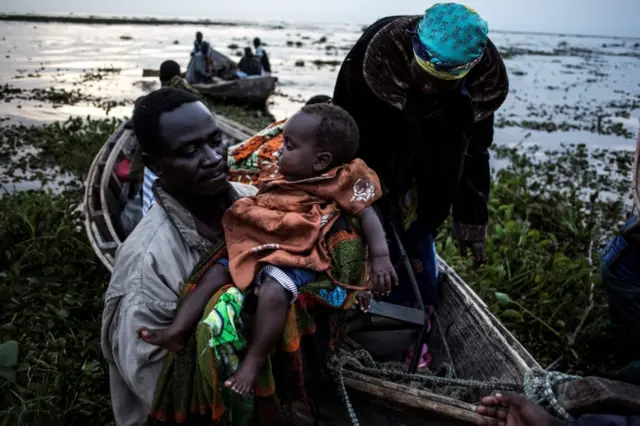 People coming off the lake after fleeing from the DR Congo