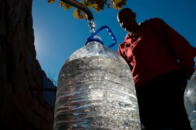 A man collects drinking water from a tap