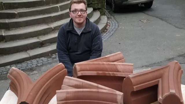 Stonemason with bits of the cathedral's new window frame