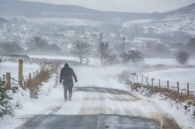 Man walking through the snow in Bangor