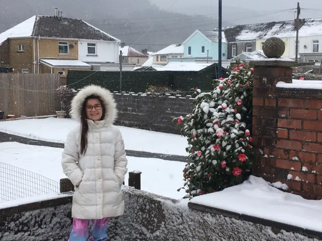 Girl in back garden in the snow