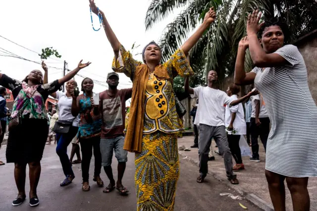 A group of Catholic faithfuls dance and chant slogans as they demonstrate outside the St Francois De Sales Church, during a protest called on by the Catholic Church, to push for the President of the Democratic Republic of the Congo, to step down on February 25, 2018 in Kinshasa. One person was killed and at least four injured as police fired live bullets and tear gas to disperse banned protests calling on DR Congo President Joseph Kabila to stand down.