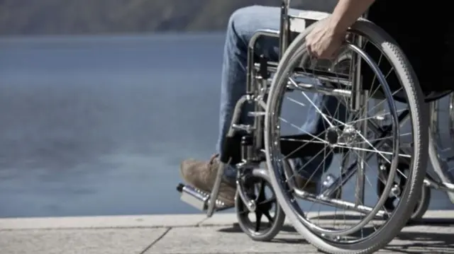 Man in a wheelchair looks over water