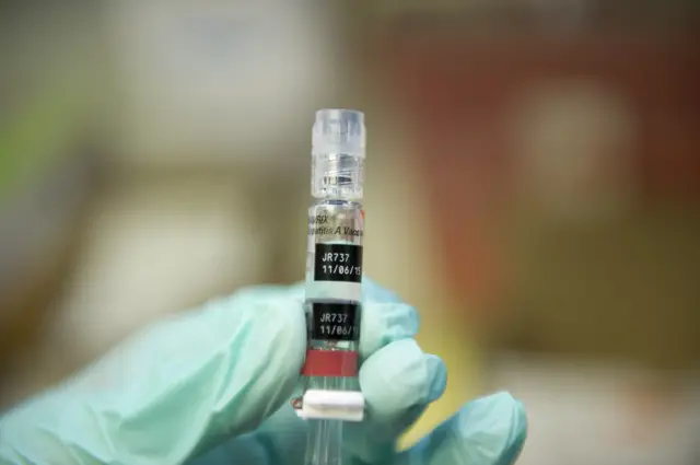 A nurse loads a syringe with a vaccine against hepatitis