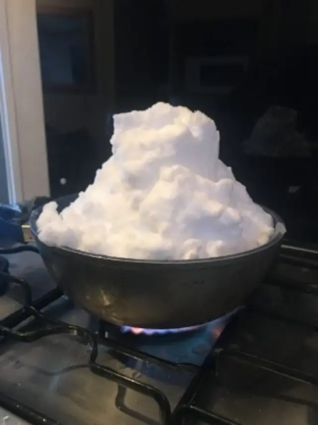 Snow melting in a pan on a hob