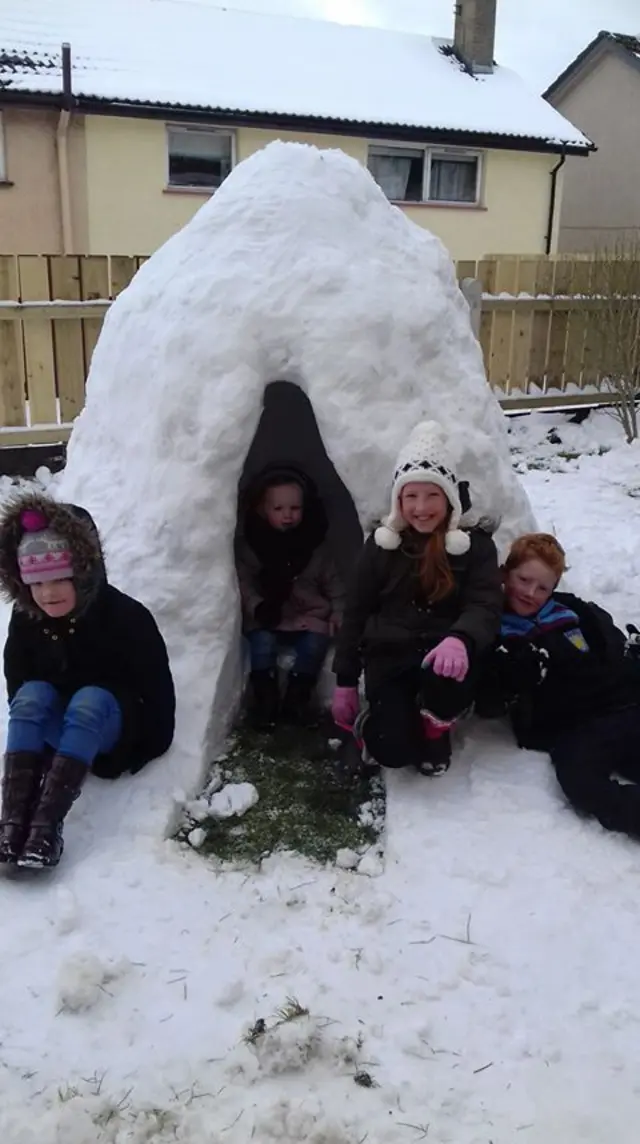 Children building an igloo out of snow