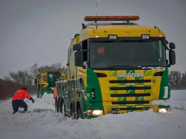 Two truck helping another tow truck