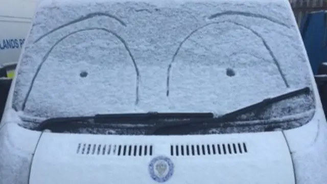 Drawing on snowed over police van