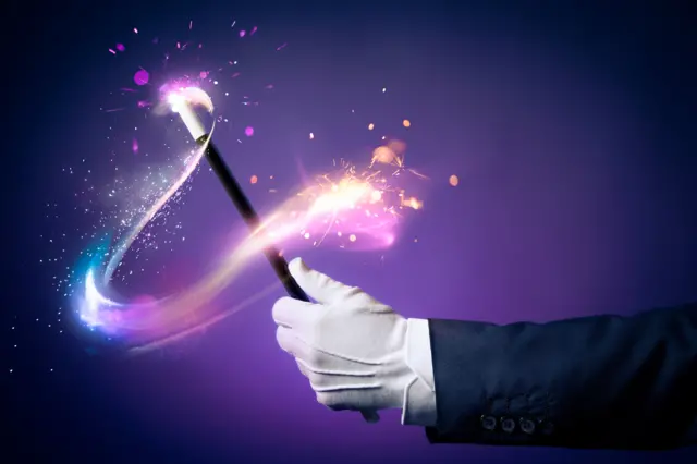 A hand holding a magic wand