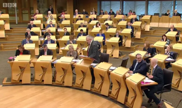 Mike Russell standing in chamber