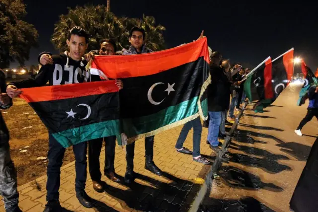 Libyans holding out the country's flag