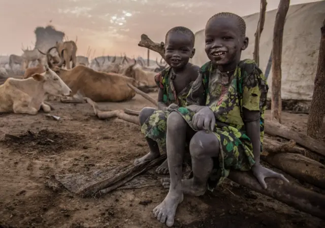 Sudanese boys from Dinka tribe pose in the early morning at their cattle camp in Mingkaman, Lakes State, South Sudan on March 4, 2018.