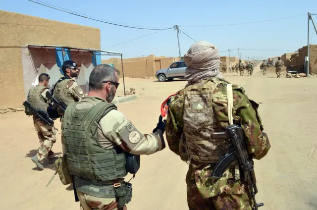 French soldiers of the Barkhane counter terrorism operation and former Tuareg rebels of the Coordination of Azawad Movements (CMA) patrol in a street on October 25, 2016, in Kidal, northern Mali,