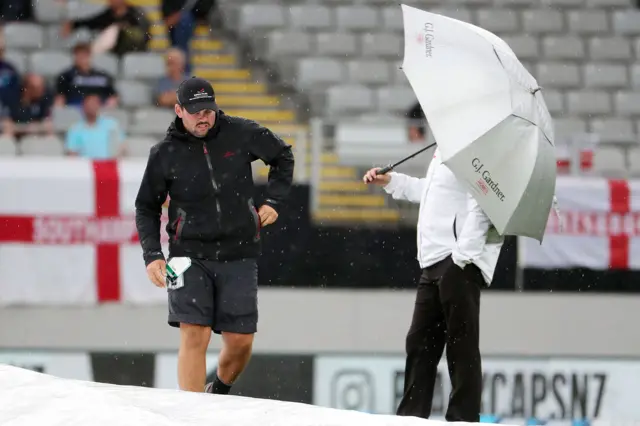 Umpires inspect the pitch