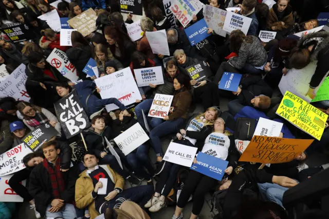 Protesters stage a "die-in" outside the US Embassy in south London