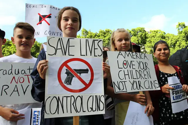 Young protesters hold placards at Hyde Park in Sydney, Australia