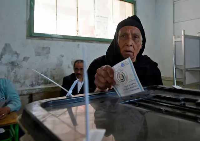 An elderly Egyptian woman casts her vote at a polling station on the first day of the 2018 presidential elections in Cairo.