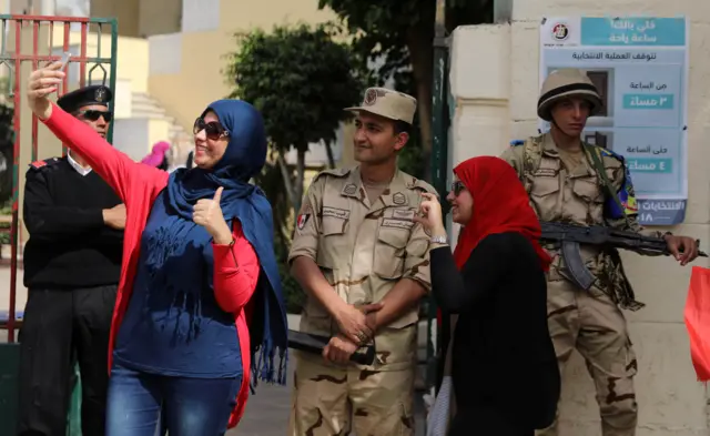 A woman takes a selfie with a solider