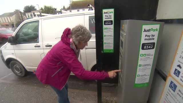 Woman getting ticket in car park